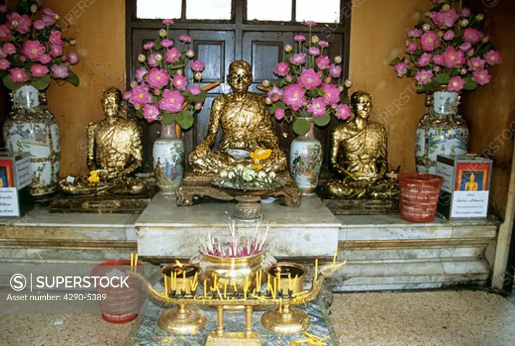 Statues, offerings, Temple of the Golden Buddha, Wat Traimit (also known as Wat Trimitr), Bangkok, Thailand