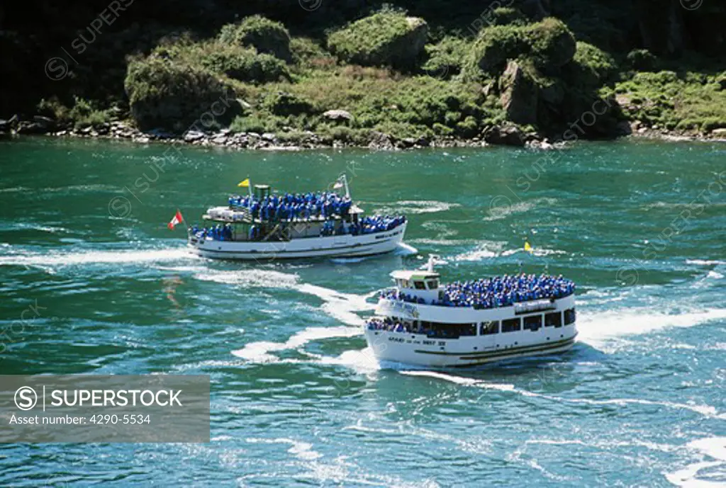 Maid of the Mist boats and tourists passing on Niagara River approaching Niagara Falls, Ontario, Canada