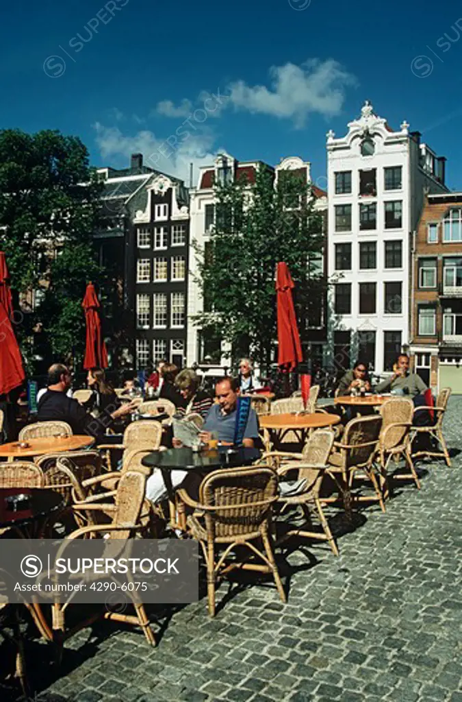People seated at outdoor cafe tables, on a bridge, Amsterdam, Holland