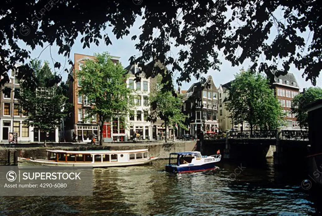 Houses overlooking canal, boats, and bridge, Amsterdam, Holland