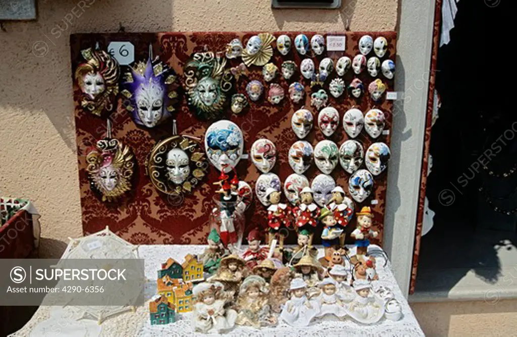 Several colourful painted face masks for sale on display outside shop, Burano, Venice, Italy