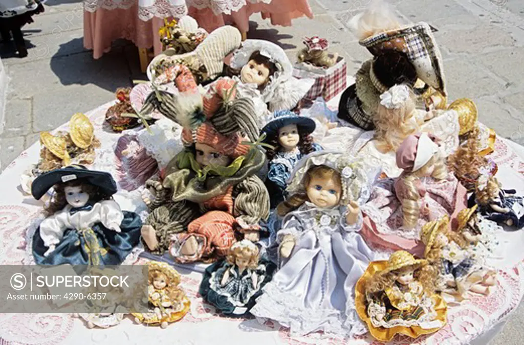 Several colourful dolls for sale on display outside shop, Burano, Venice, Italy