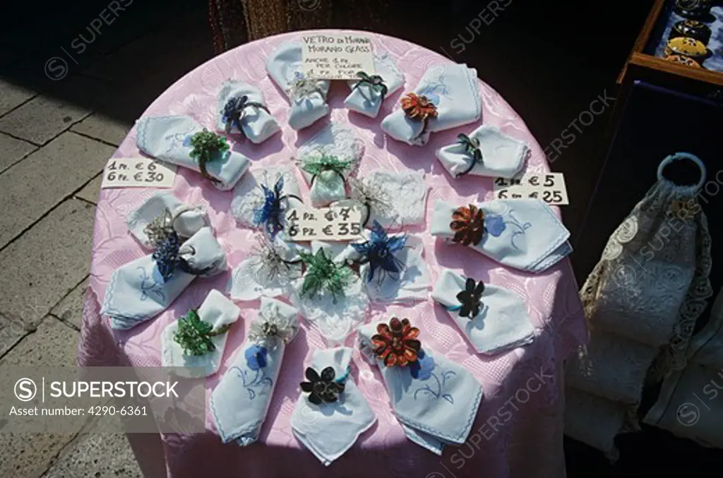 Murano glass napkin rings and napkins for sale on display outside shop, Burano, Venice, Italy