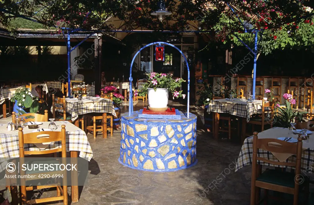 Water well and tables and chairs in restaurant, Lassi, Kefalonia, Greece