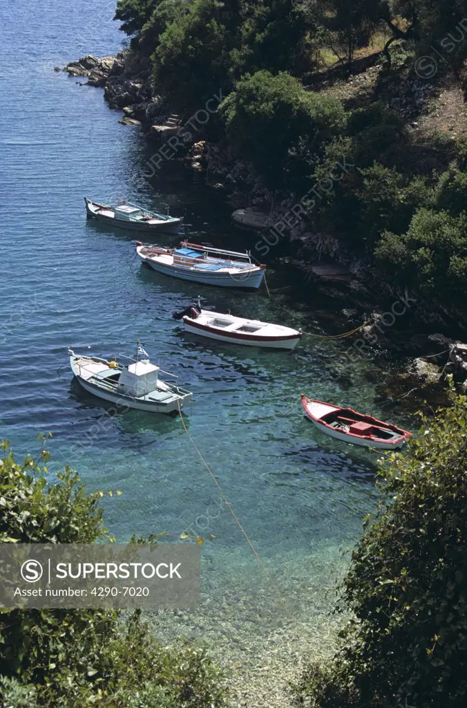 Fishing boats moored in natural cliff side harbour, Kioni, Ithaca, Greece