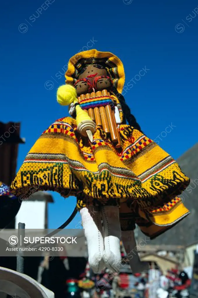 Colourful yellow doll on a stall in the market, Ollantaytambo, Sacred Valley of the Incas, near Cusco, Peru