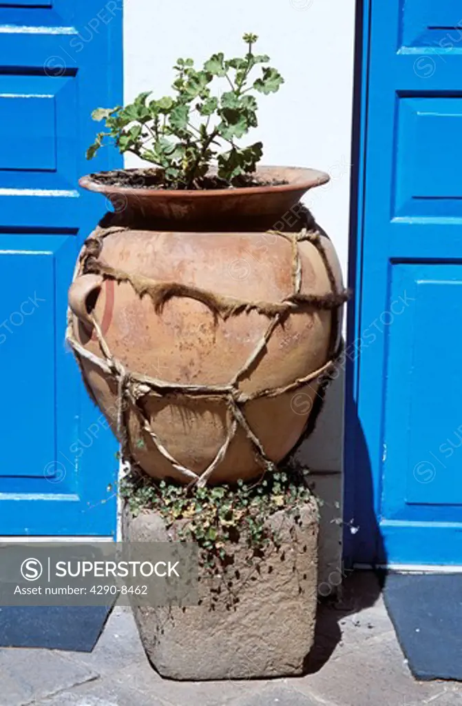 Large pot on plinth between two blue painted doors and white wall, Cusco, Peru