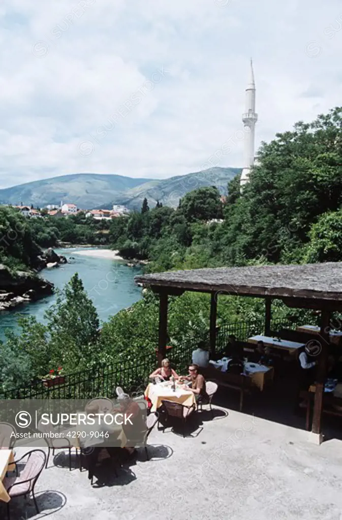 Tourists dining outside beside Neretva River, Mostar, Bosnia Herzegovina, Former Yugoslavia