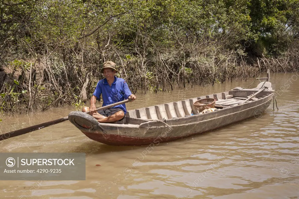 Vietnam, Mekong River Delta, Cai Be, Vietnamese man rowing long boat