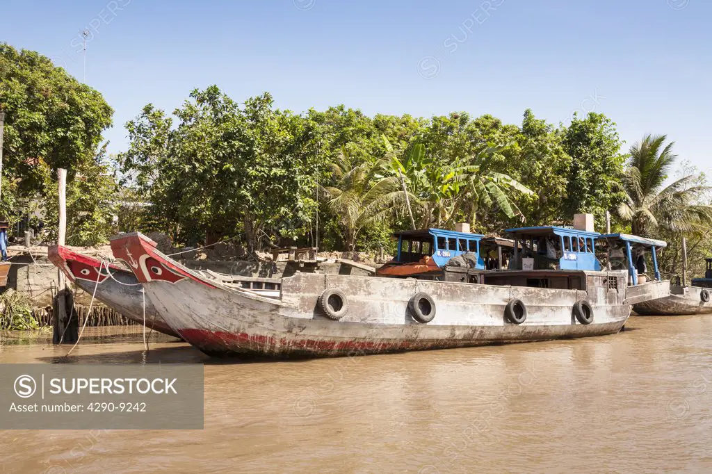 Vietnam, Mekong River Delta, between Cai Be and Vinh Long, typical cargo boats moored on river