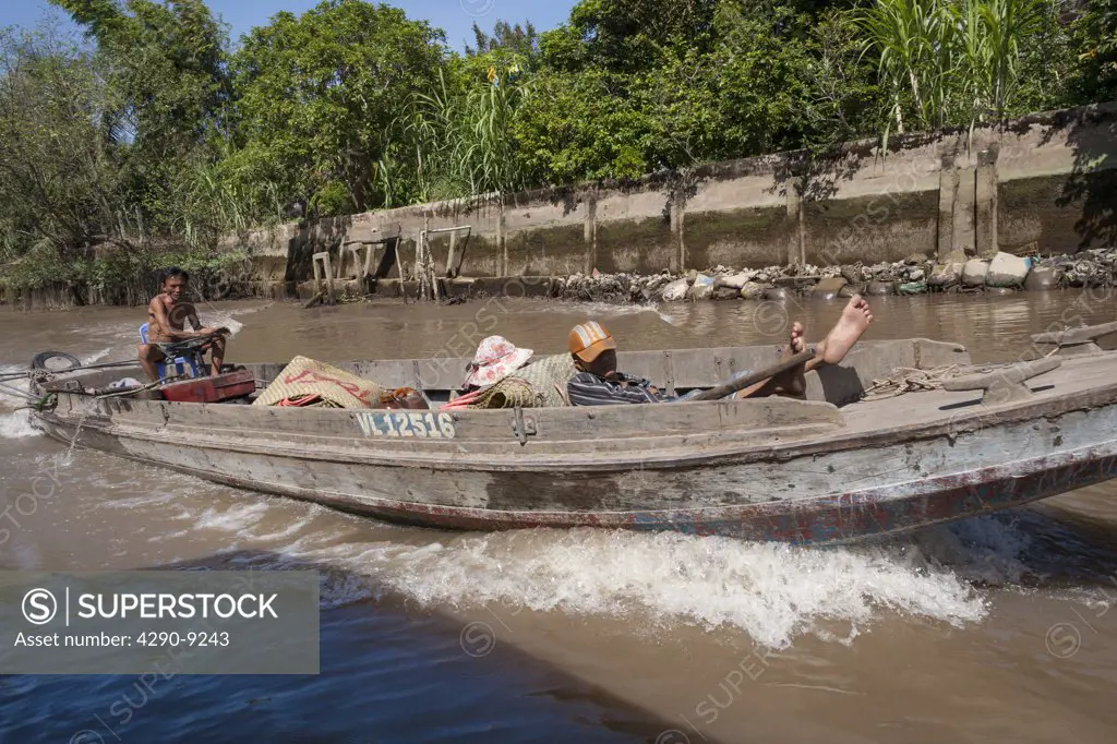 Vietnam, Mekong River Delta, between Cai Be and Vinh Long, Vietnamese men travelling in long boat
