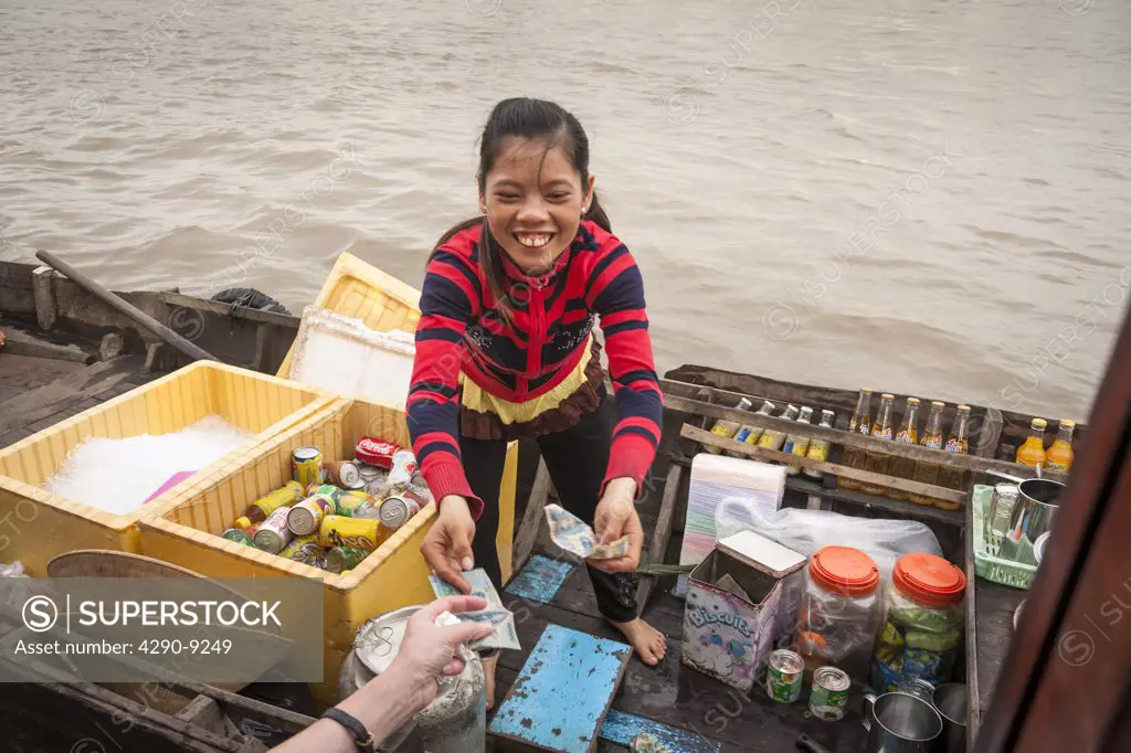 Vietnam, Mekong River Delta, Cai Rang, near Can Tho, young girl selling drinks from boat in floating market