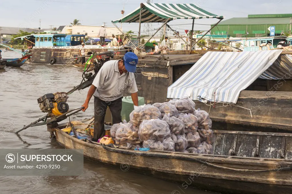 Vietnam, Mekong River Delta, Cai Rang, near Can Tho, man selling vegetables from boat in floating market