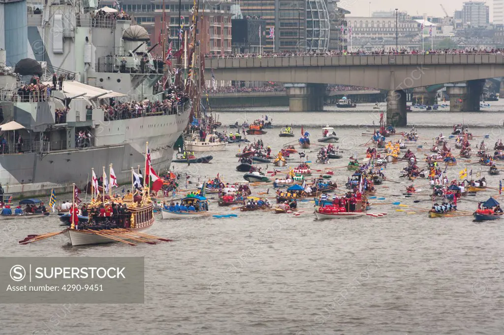UK, England, London, Numerous small rowing boats on River Thames past HMS Belfast as part of Queen's Thames Diamond Jubilee Pageant