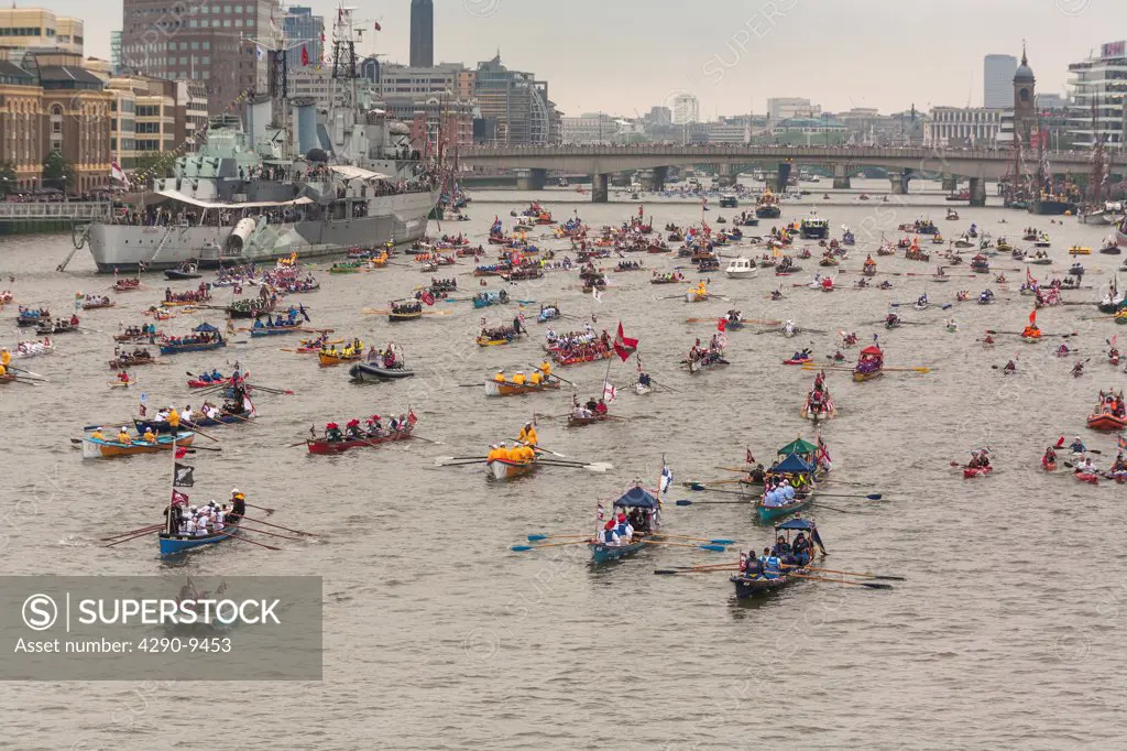 UK, England, London, Numerous small rowing boats on River Thames past HMS Belfast as part of Queen's Thames Diamond Jubilee Pageant