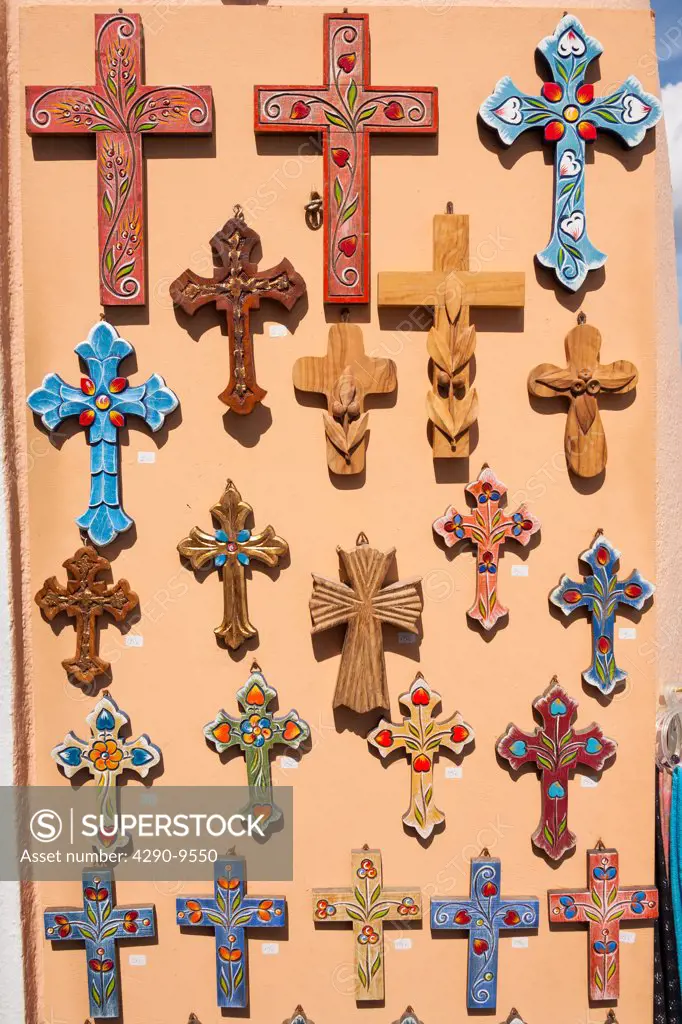 Decorative colourful religious crucifixes for sale outside a gift shop, Oia, Santorini, Greece