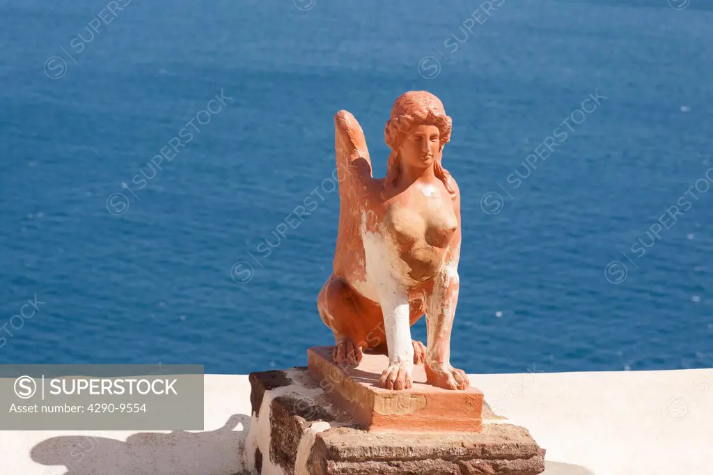 A sphinx statue beside the Aegean Sea, Oia, on the Greek island of Santorini, Greece