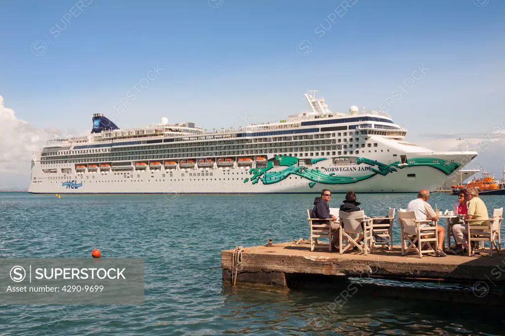 Tourists dining alfresco in front of the Norwegian Jade cruise ship, Katakolon, Greece