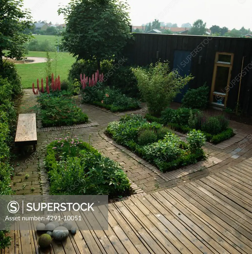 Formal beds with decking and paved paths in large country garden