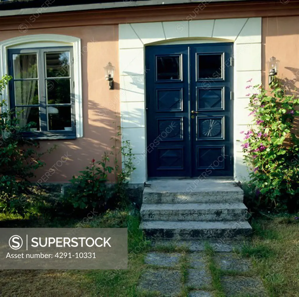 Steps to blue double door in traditional Scandinavian cottage