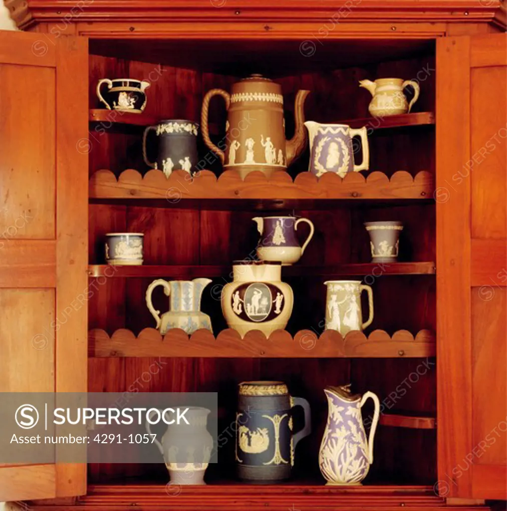 Close-up of antique Wedgewood jugs on dresser shelves