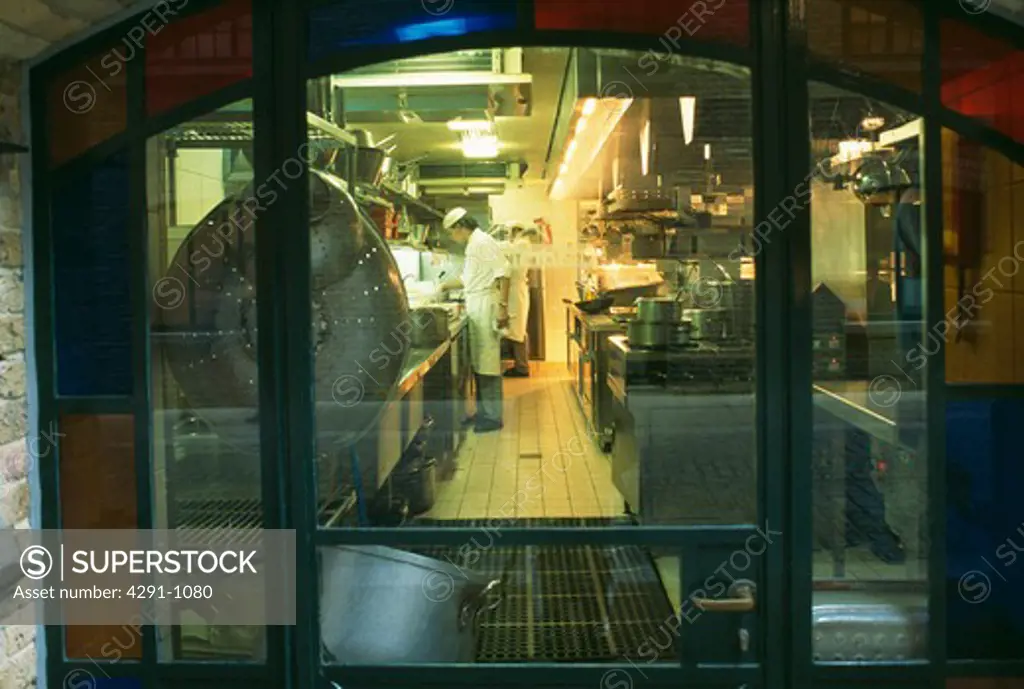 View through window of chefs in kitchen of modern restaurant