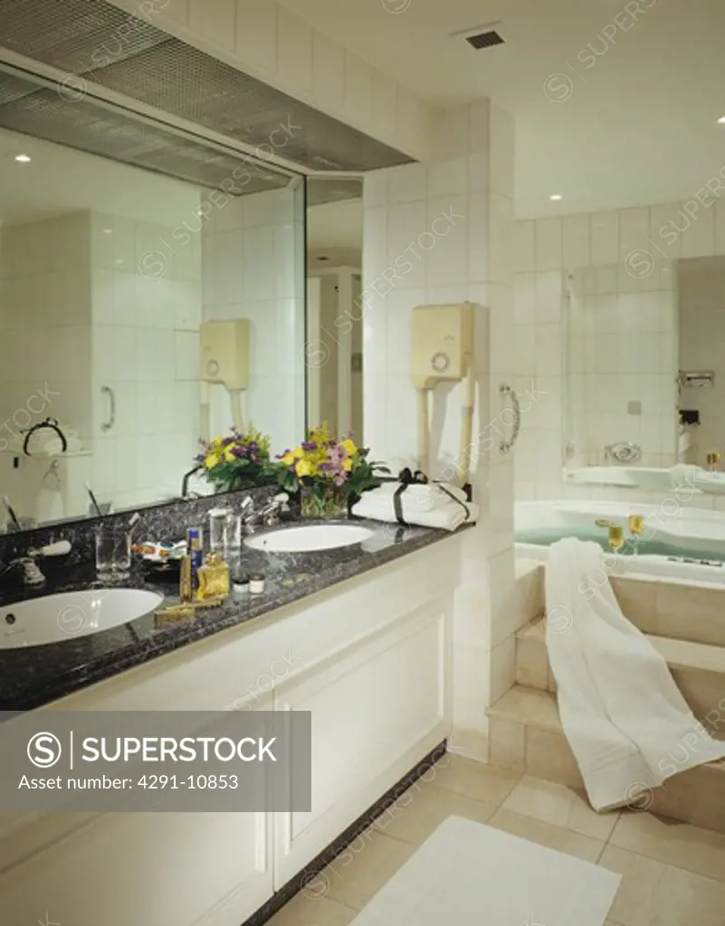 Mirror above basins underset in granite-topped vanity unit in modern bathroom