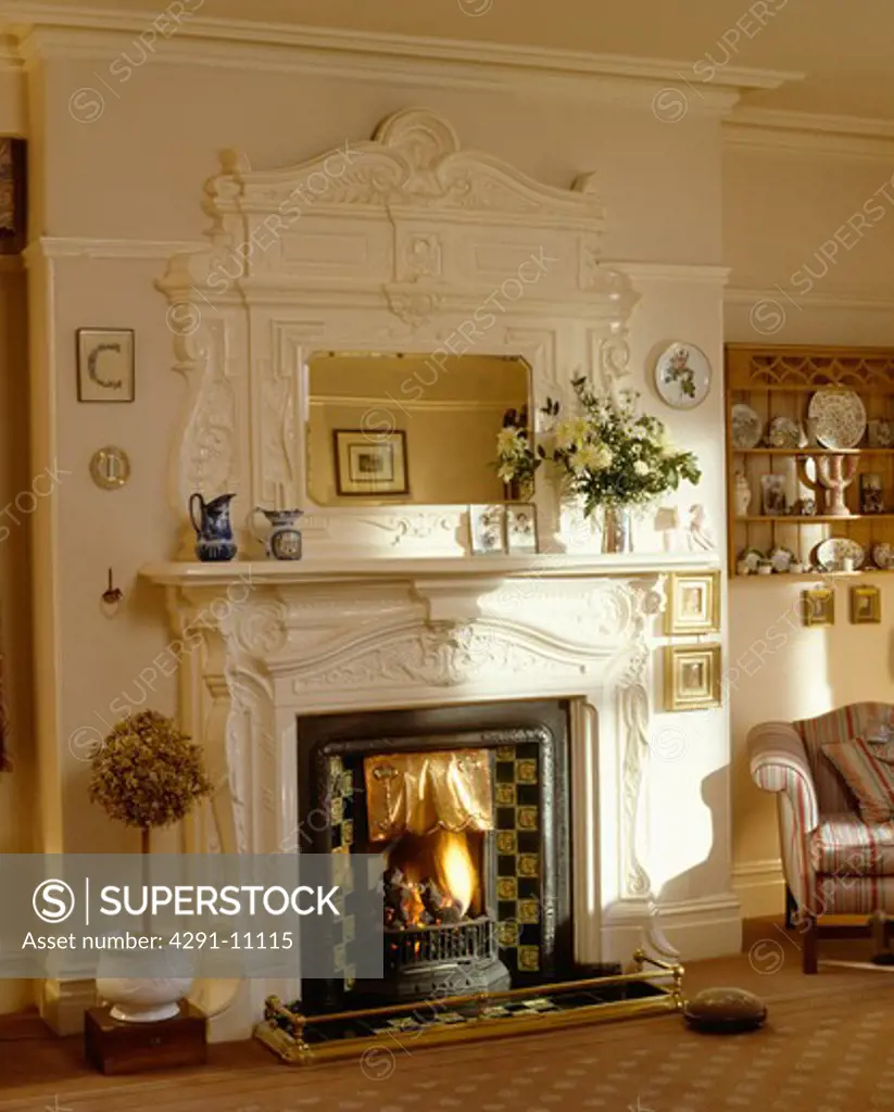 White overmantel mirror above traditional white fireplace