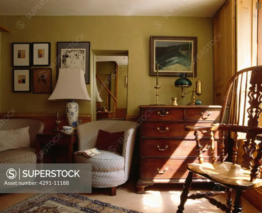 Tub armchairs and antique chest-of-drawers in traditional cottage living room