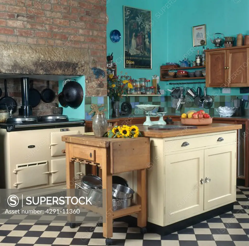 Butcher's block and island unit in turquoise country kitchen with cream Aga oven