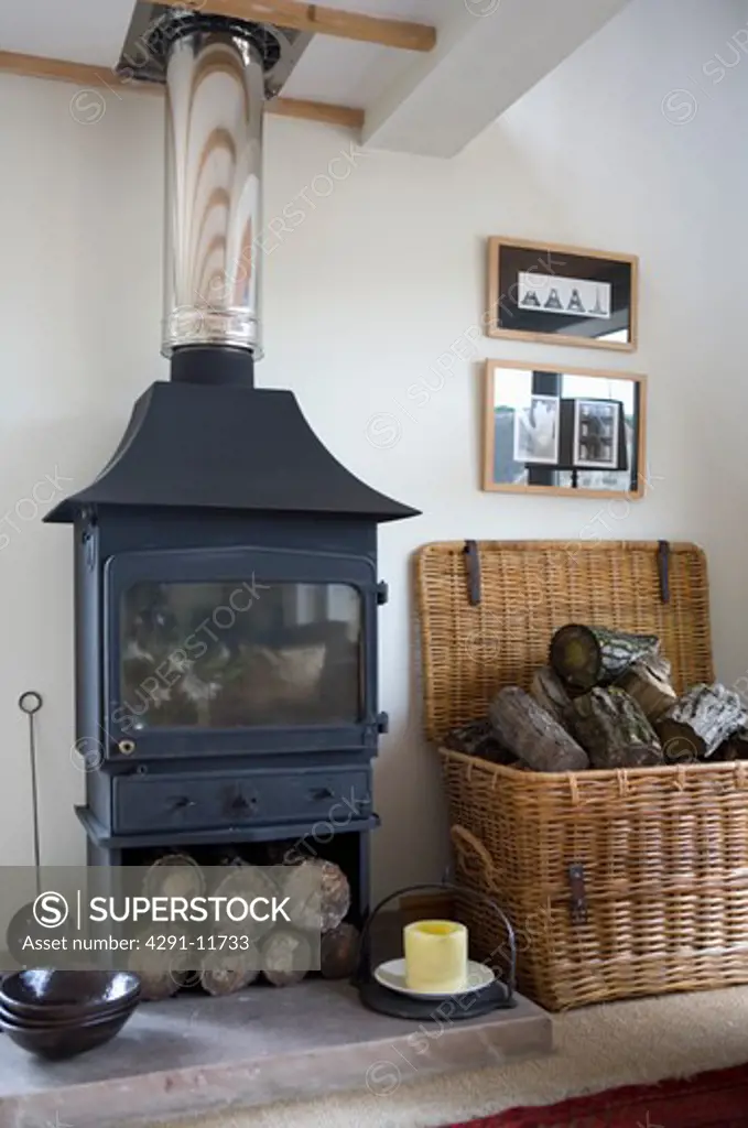 Close up of black cast iron stove and large basket of logs
