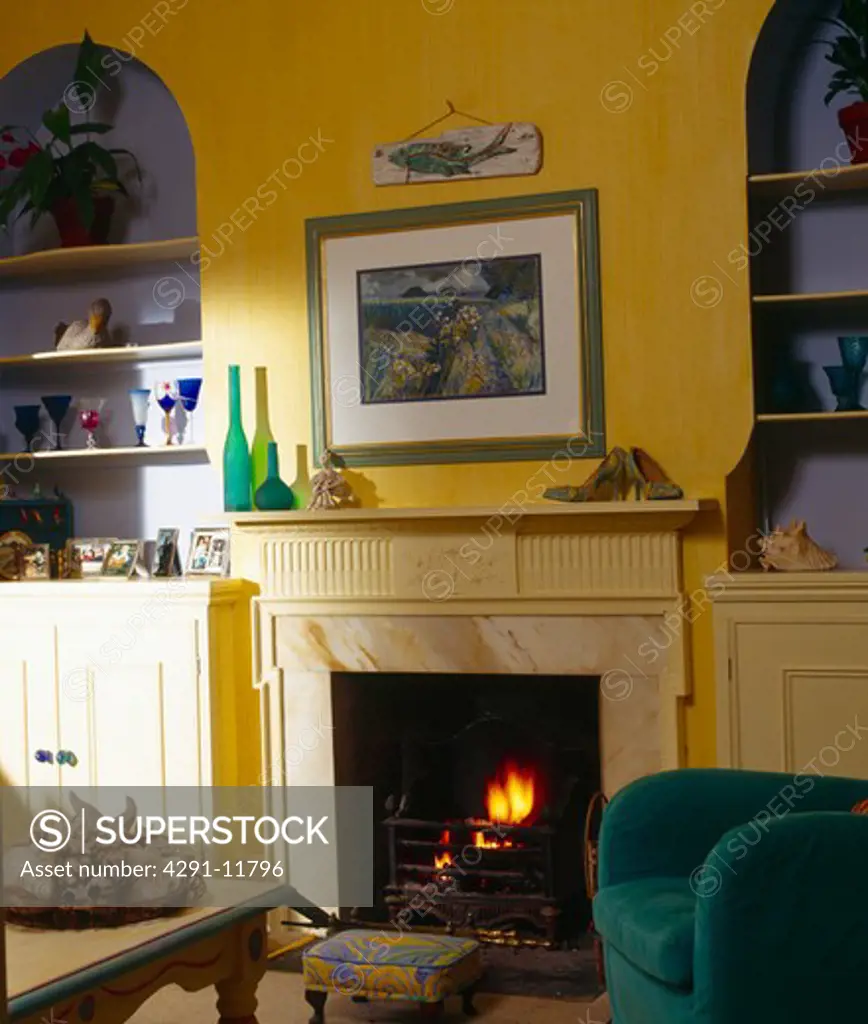 Picture above fireplace in yellow living room with blue alcoves