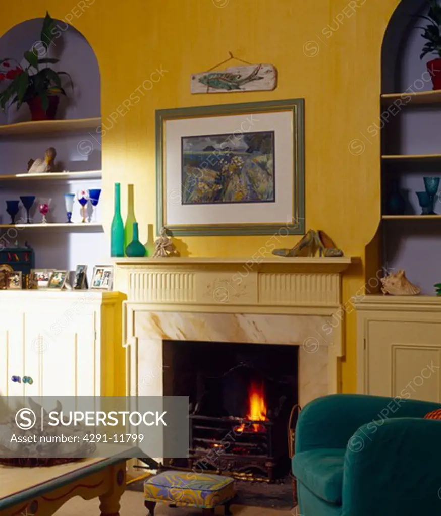 Picture above fireplace in yellow living room with blue alcoves
