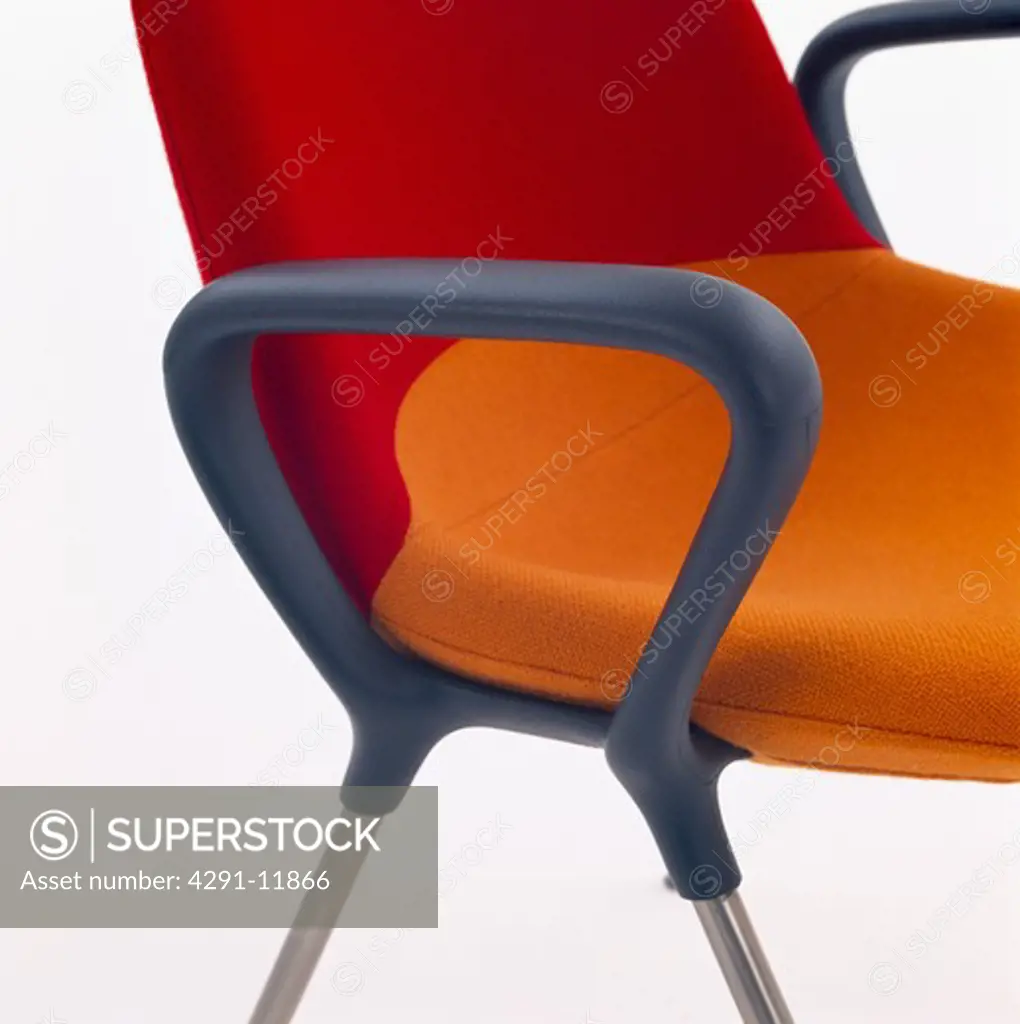Close-up of modern office chair with red and orange seat