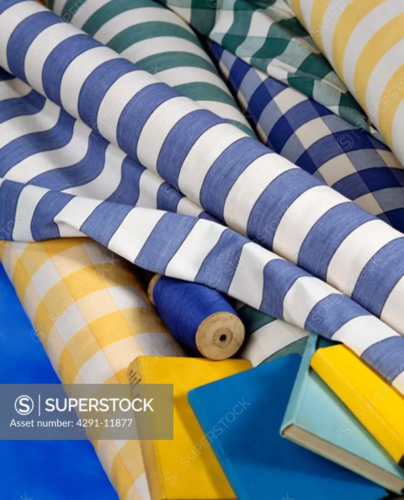 Close-up of rolls of blue and white striped and checked cotton fabric