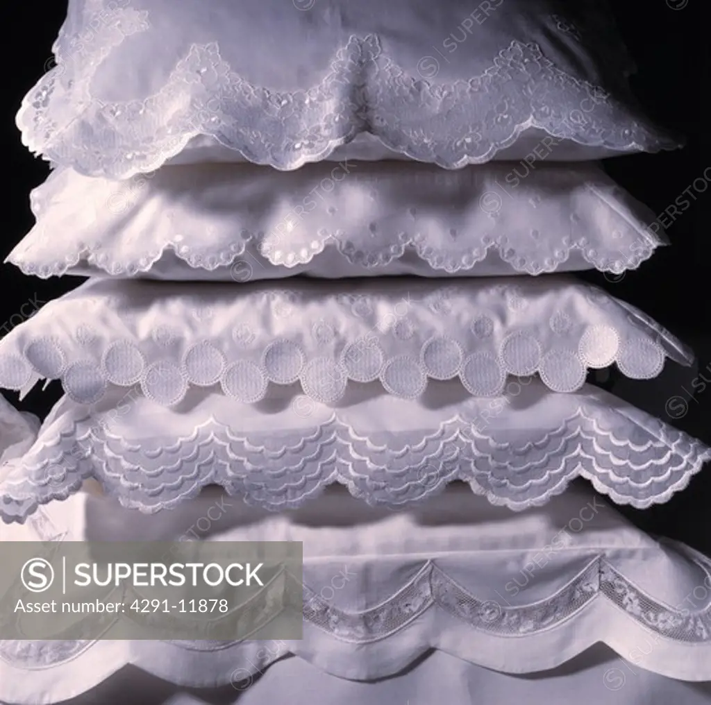White pillows in decorative pillow cases in stack