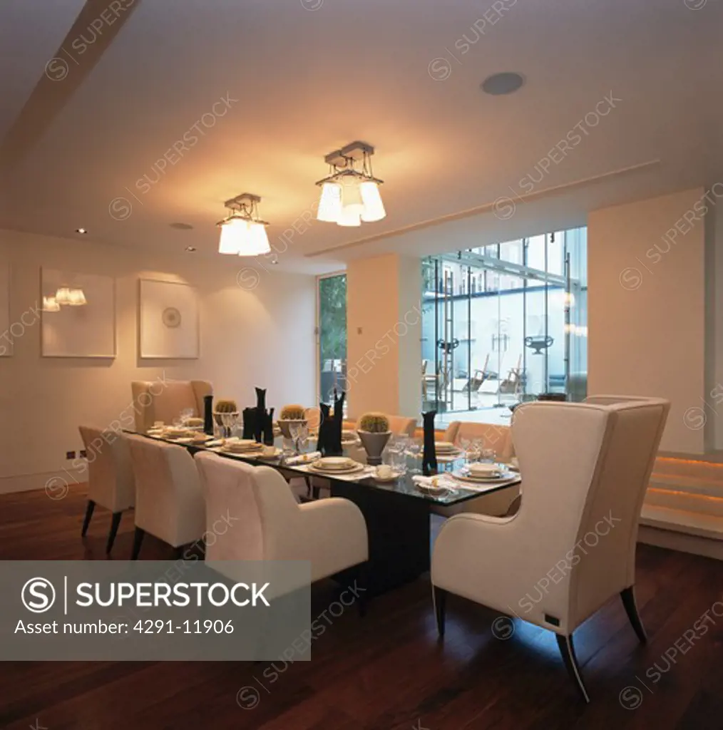 White chairs at table in modern white dining room