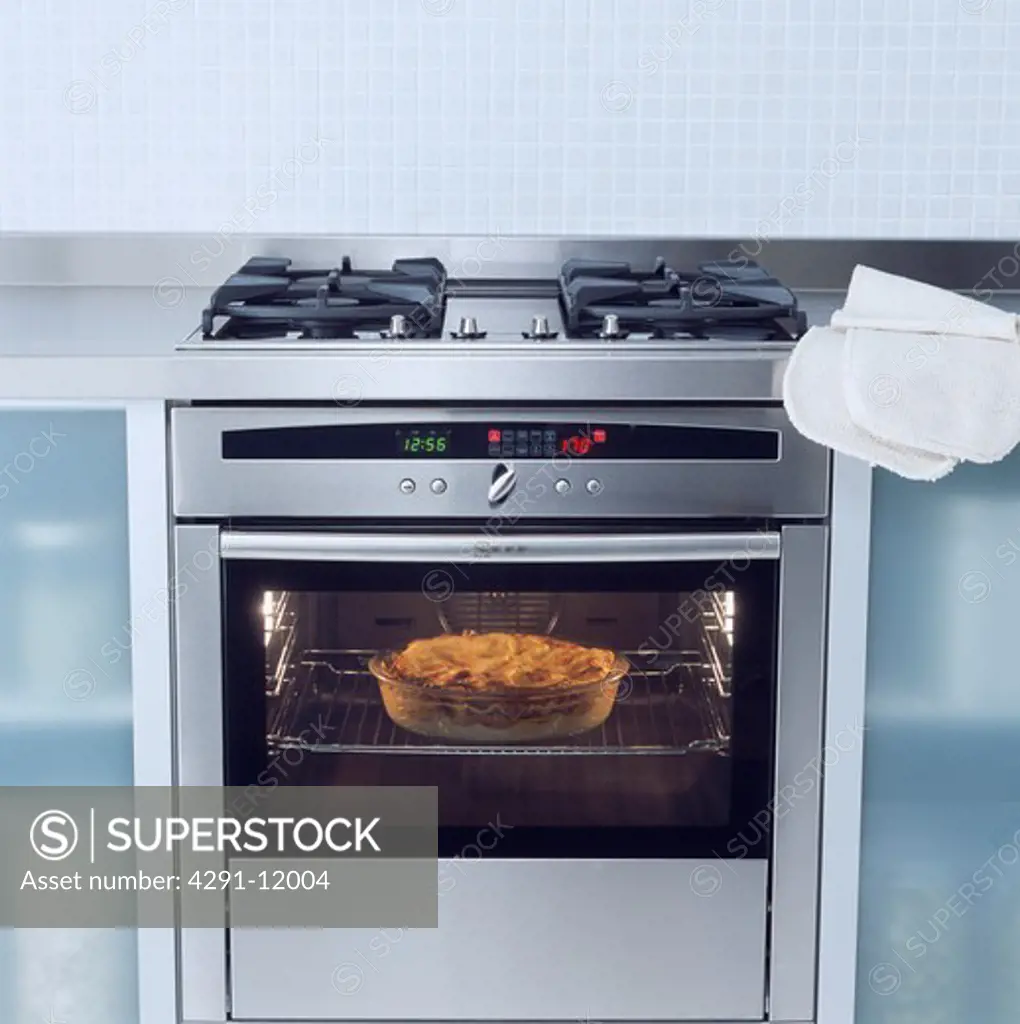 Close-up of pie cooking in stainless steel oven with glass door