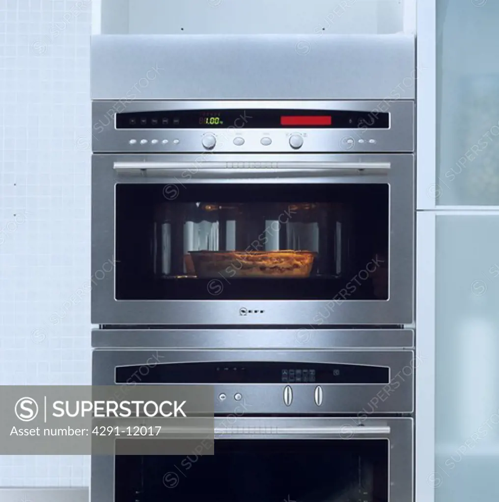 Close-up of pie cooking in double stainless steel oven with glass door