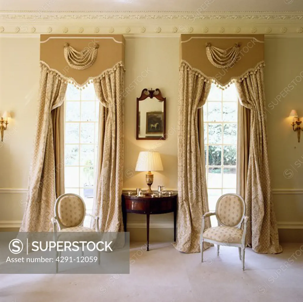 Ornate pelmets above cream curtains in traditional drawing room