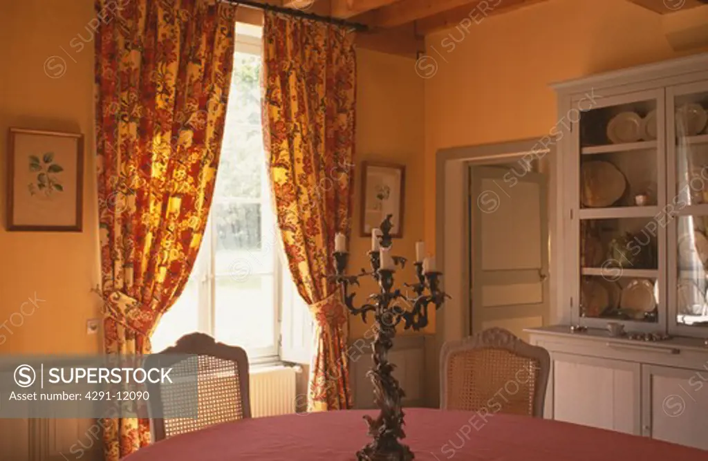 Yellow and red floral curtains in diningroom with yellow walls and grey paintwork