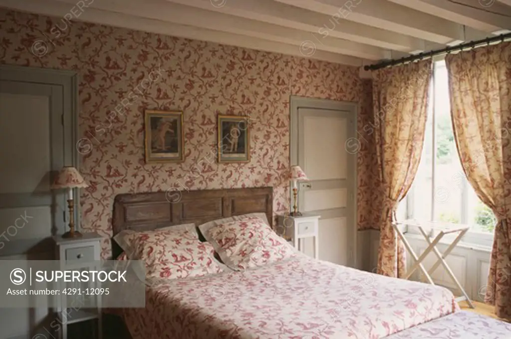 Red Toile de Jouy wallpaper in country bedroom with matching bedlinen and curtains