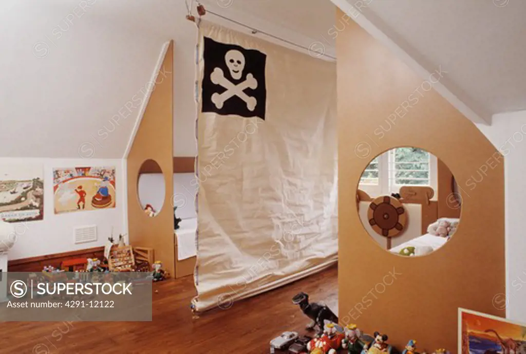 Canvas room divider with scull and crossbones motif in children's bedroom with cut-out circles inplywood bed ends