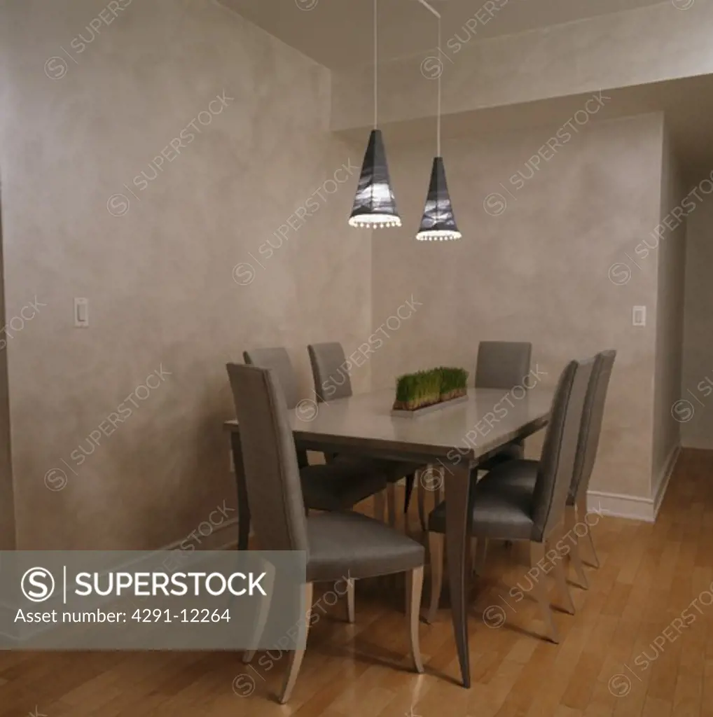 Grey silk upholstered chairs at table in grey dining room with sponge-effect walls
