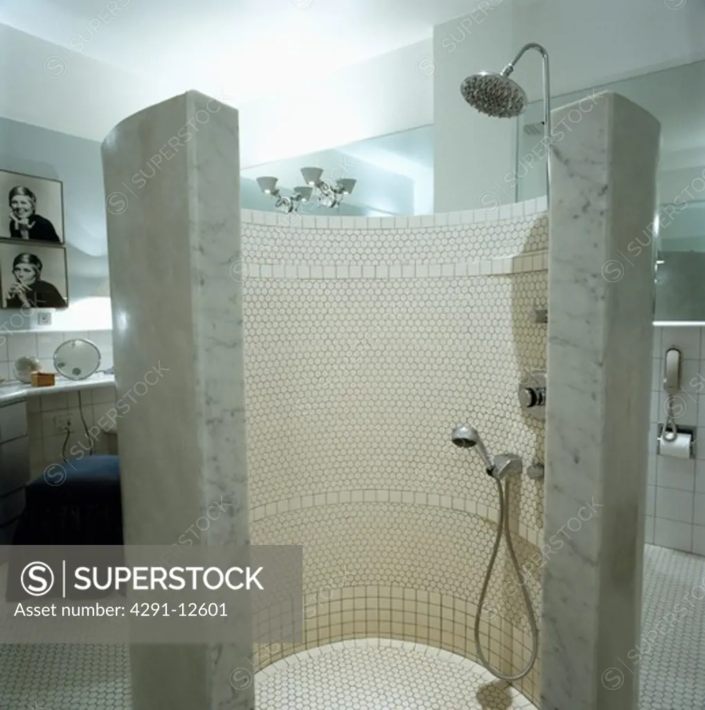 Marble and mosaic-tiled curved walk-in shower cabinet in modern white tiled city bathroom