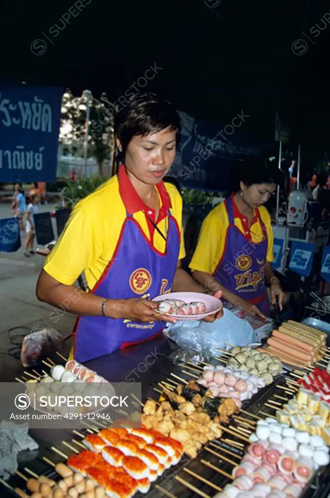 Woman working on outdoor food stall, Phitsanulok, Thailand