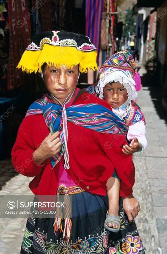 Young girl with her sister on her back, Pisac Market, Pisac, near Cusco, Peru