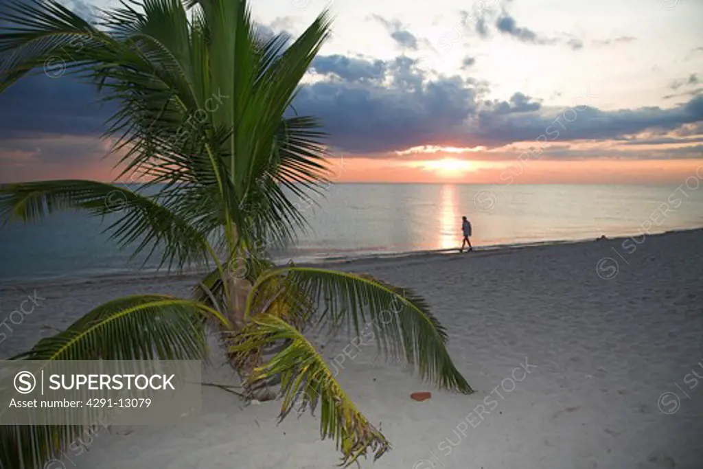 Man walking along beach at sunset, Trinidad, Sancti Spiritus Province, Cuba