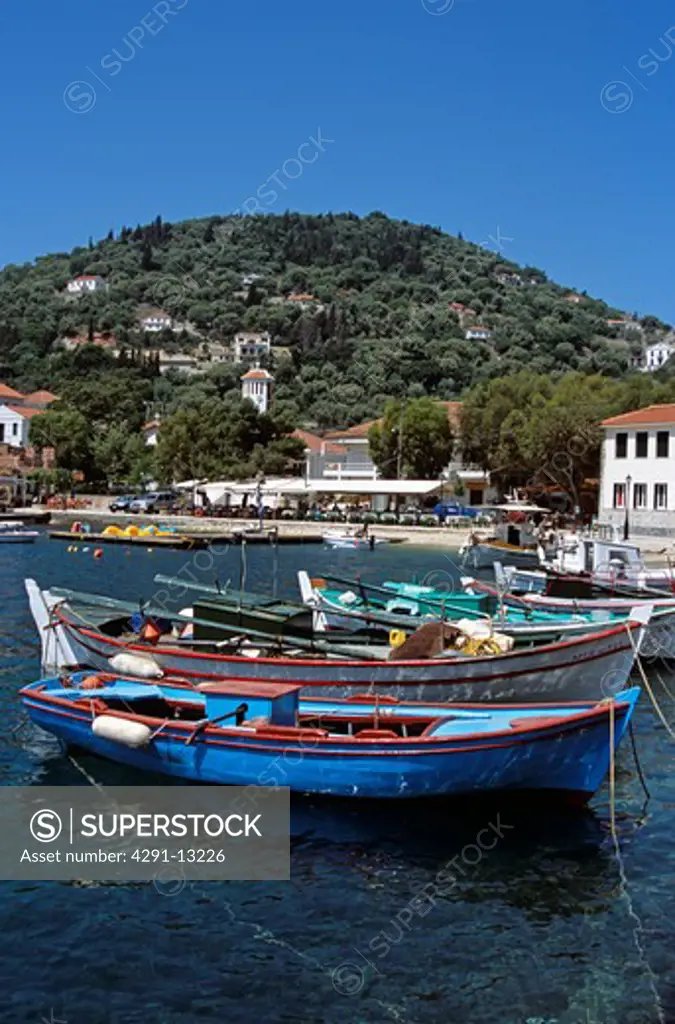 Fishing boats moored in Kioni harbour and houses and apartments on hillside, Kioni, Ithaca, Greece