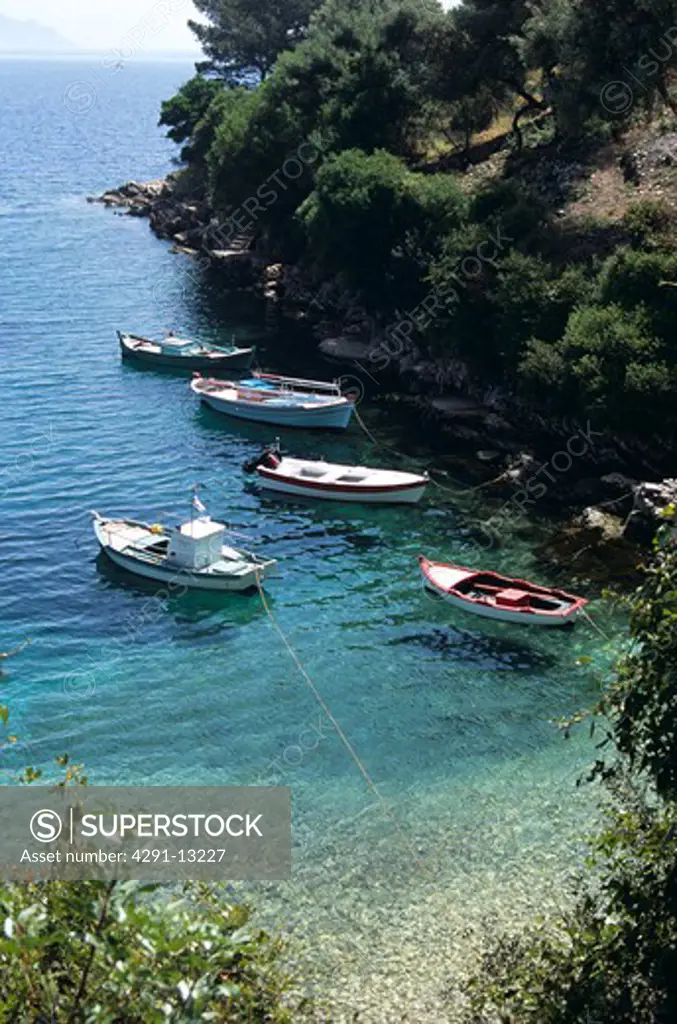 Fishing boats moored in natural cliff side harbour, Kioni, Ithaca, Greece
